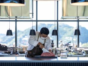 Takiにある旅籠ヴィソンの台所のカウンターで肉を調理する料理人