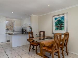 a kitchen and dining room with a table and chairs at Glen Abbey Apartments On The Erinvale Golf And Country Estate in Somerset West