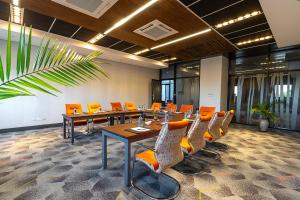 une salle de conférence avec des tables et des chaises orange dans l'établissement Holiday Inn - Nairobi Two Rivers Mall, an IHG Hotel, à Nairobi