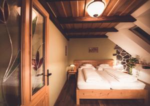 um quarto com uma cama e uma porta de madeira em Penzion a Restaurace U Johana em Zlín