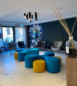 a waiting room with blue and yellow tables and chairs at Solho Hotel in Bardolino