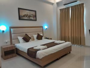 a bedroom with a large bed with two towels on it at Hotel The Luxem - Behind Ibis Hotel Gurugram in Gurgaon