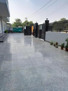 an empty patio with a fence and potted plants at Hotel The Luxem - Behind Ibis Hotel Gurugram in Gurgaon