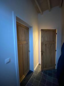 um quarto com 2 portas de madeira e um piso de azulejo em Sulfer7 em Heuvelland