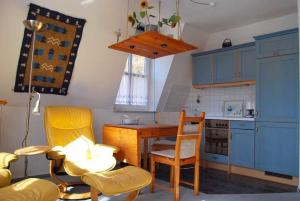 バンシンにあるVilla Margot Whg 16のキッチン(青いキャビネット、テーブル、椅子付)