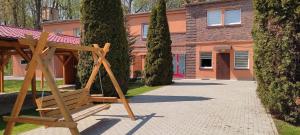 a wooden swing sitting in front of a building at Motel Sportowy OSiR Jawor in Jawor