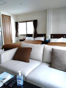 a living room with a couch and two beds at Sankei Hiranomachi Building - Vacation STAY 13206 in Osaka