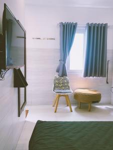 a bedroom with a tv and a chair and a window at Lighthouse Homestay Vũng Tàu in Vung Tau