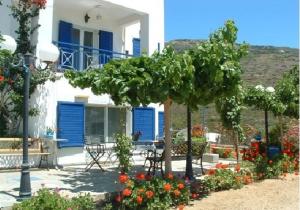 キプリにあるVilla Zefirosの青い扉と庭の木のある家
