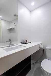 宿霧市的住宿－Sarrosa International Hotel and Residential Suites，白色的浴室设有水槽和卫生间。