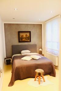 a bedroom with a large bed and a stool at 3C-Apartments in Ghent