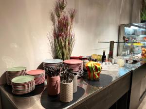 a counter with a bunch of plates and vases at ibis Styles Ljubljana Centre in Ljubljana