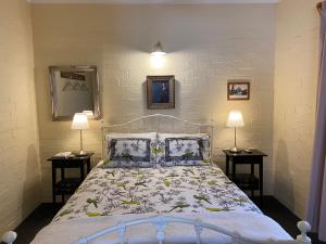a bedroom with a bed with two lamps on two tables at Battunga Cottages in Watervale
