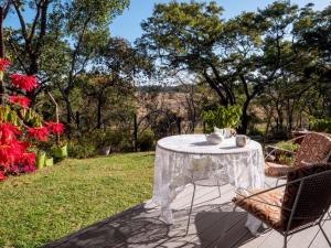 a white table and chairs on a patio with trees at Nature on the HIll in Harare
