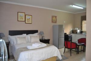 a bedroom with a bed with towels on it at Green Grove Villa in Centurion