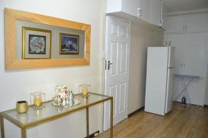 a kitchen with a table and a refrigerator at Green Grove Villa in Centurion