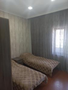 2 camas en una habitación de hotel con ventana en Gam guest house 2 en Meghri