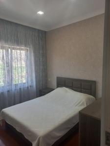 1 dormitorio con cama blanca y ventana en Gam guest house 2 en Meghri