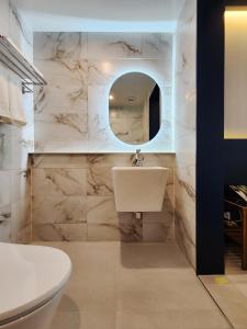 a bathroom with a white toilet and a sink at Gold Stone Hotel in Busan