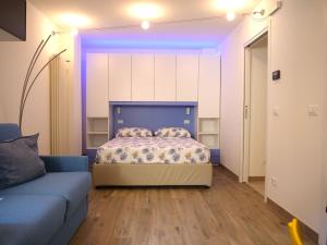 ein Schlafzimmer mit einem Bett und einem Sofa in einem Zimmer in der Unterkunft LondonSuite - nuovissimo mini Appartamento in Grado