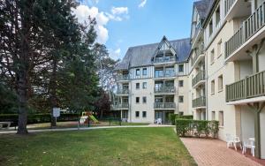 an apartment building with a lawn in front of it at Residence Pierre & Vacances Les Embruns in Deauville