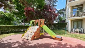 une aire de jeux avec toboggan en face d'une maison dans l'établissement Residence Pierre & Vacances Les Embruns, à Deauville