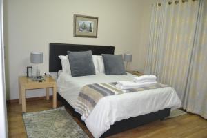 a bedroom with two beds and a table with two lamps at Green Grove Villa in Centurion