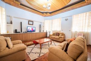 sala de estar con 2 sofás y TV en spacious & stylish 4bdr kileleshwa, en Nairobi