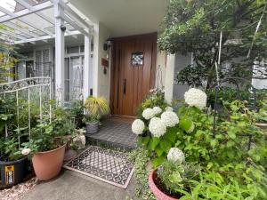 una puerta de entrada de una casa con un montón de plantas en 叶 en Nishikichō