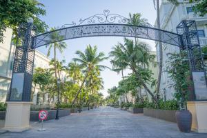 an archway in the middle of a street with palm trees at V&T Hotel Phu Quoc - 3 minutes to Beach in Phú Quốc