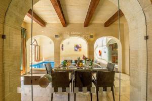 a dining room with a table and some chairs at The Hamlet 2 Holiday Home in Għasri