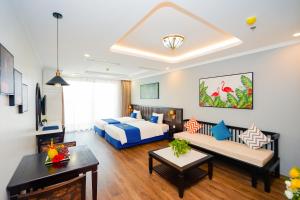 a hotel room with a bed and a couch at D'Lioro Hotel & Resort in Ha Long