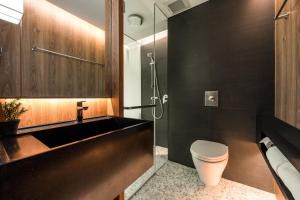 a bathroom with a sink and a toilet and a shower at Volve Hotel Bangkok in Bangkok
