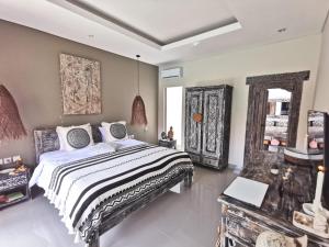 1 dormitorio con 1 cama grande y espejo en Kubu Garden Suites & Villas Nusa Dua, en Nusa Dua