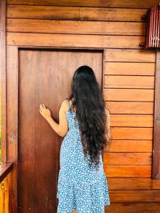 Una donna in piedi davanti a una porta di legno di Misty Mountain- Sinharaja a Deniyaya