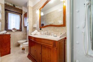a bathroom with a sink and a toilet and a mirror at Locazione Turistica Fusillo Lorusso con parcheggio privato in loco in Barletta +20 photos