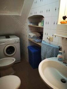 uma casa de banho com um lavatório e uma máquina de lavar roupa em Locazione turistica Lorusso 1 em Andria