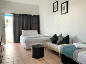a hotel room with two beds and a couch at Aqua Blue Motel in Gold Coast