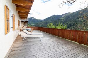 a deck with chairs and a view of mountains at Unterwegerhof in Tires
