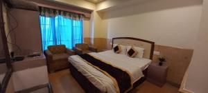 מיטה או מיטות בחדר ב-Shorya Regency