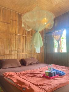 a bedroom with a bed with a table on it at ลุงนะ โฮมสเตย์ ปางอุ๋ง แม่ฮ่องสอน in Ban Huai Makhuea Som