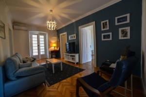 uma sala de estar com paredes azuis e um sofá e cadeiras em Apartment Villa Oliva em Gostinjac