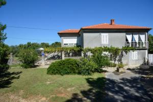 una casa blanca con una valla y un patio en Apartment Villa Oliva en Gostinjac