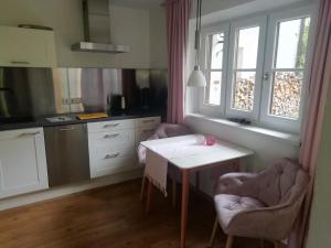 een keuken met een witte tafel en 2 stoelen bij BergZeit Apartment in Berchtesgaden