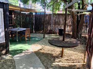 een patio met een tafel, een boom en een hek bij The shack life in Rensburgdorp