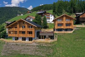 a group of wooden houses on a hill at Canalhof in Antermoia