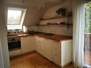 a kitchen with white cabinets and a sink and a window at Leśniczówka in Lądek-Zdrój