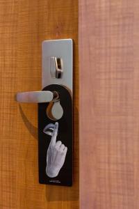 a doorhandle with a picture of a hand and a knife at Volve Hotel Bangkok in Bangkok