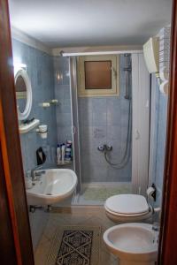 y baño con ducha, aseo y lavamanos. en Appartamento Erice Bassa, en Trapani