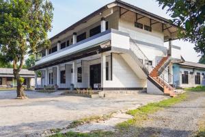 un edificio antiguo con una escalera delante en SPOT ON 91797 Mutiara Guest House, en Karawang